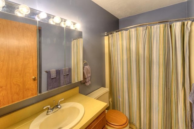 full bath with vanity, toilet, and curtained shower