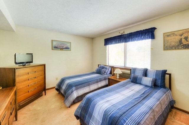 bedroom featuring light colored carpet and baseboards