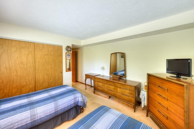 bedroom featuring light colored carpet and a closet