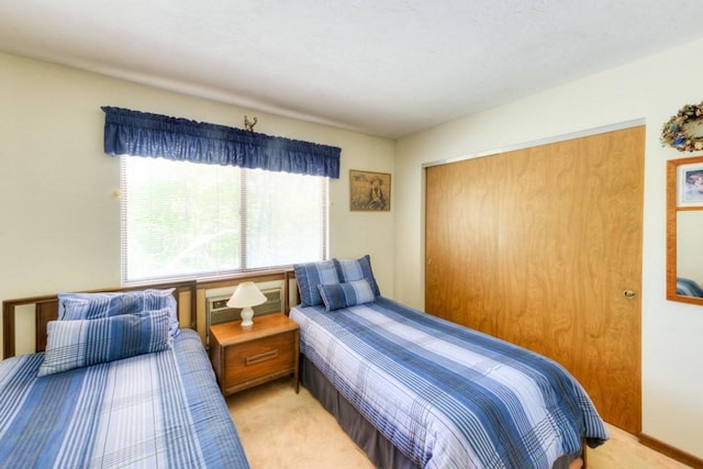 bedroom featuring light carpet and a closet