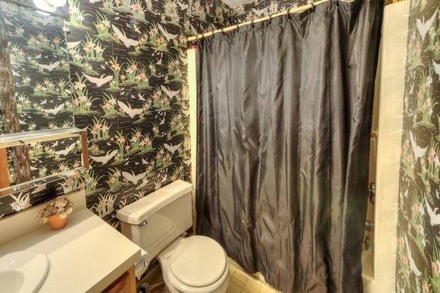 full bathroom featuring wallpapered walls, vanity, and toilet