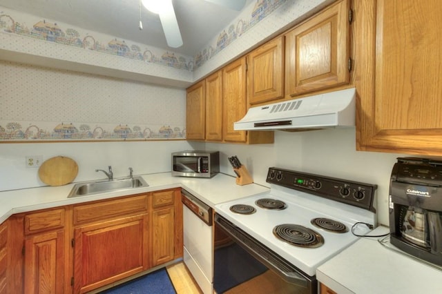 kitchen featuring white appliances, under cabinet range hood, a sink, and light countertops