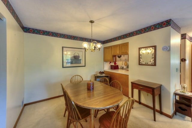 dining space featuring light carpet, a chandelier, and baseboards
