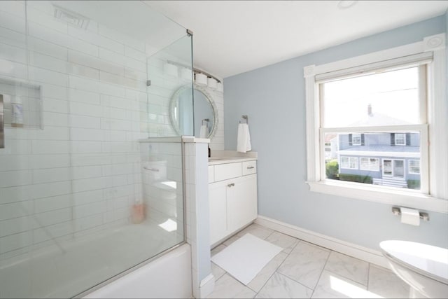 bathroom with toilet, marble finish floor, vanity, enclosed tub / shower combo, and baseboards