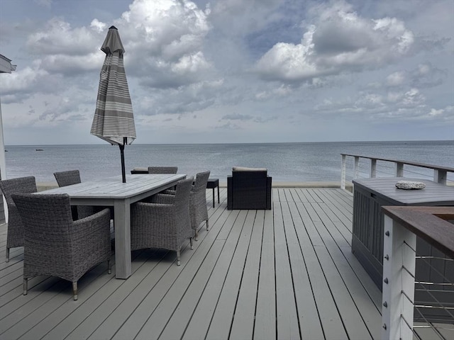 wooden deck featuring a water view and outdoor dining space