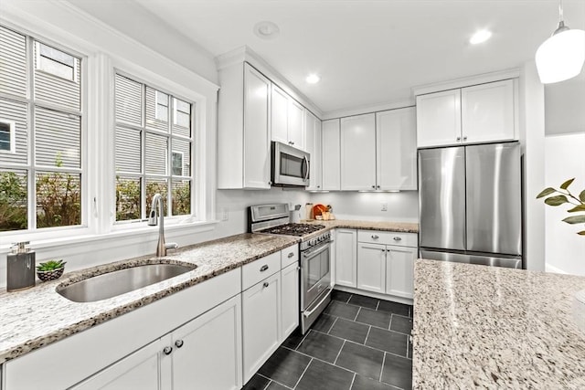 kitchen featuring sink, decorative light fixtures, white cabinets, and appliances with stainless steel finishes