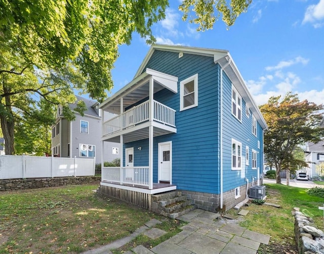 view of front of house featuring central AC unit and a balcony