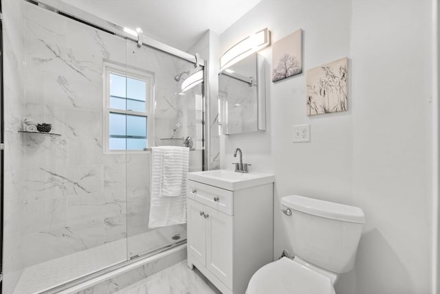 bathroom featuring vanity, toilet, and a shower with shower door