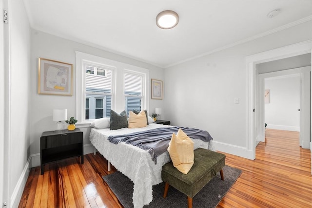 bedroom with crown molding and light hardwood / wood-style floors