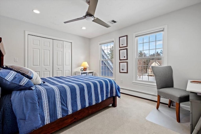 bedroom with recessed lighting, a closet, visible vents, a baseboard heating unit, and light carpet