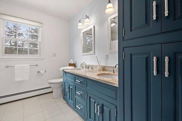 bathroom featuring double vanity, baseboard heating, a sink, and toilet