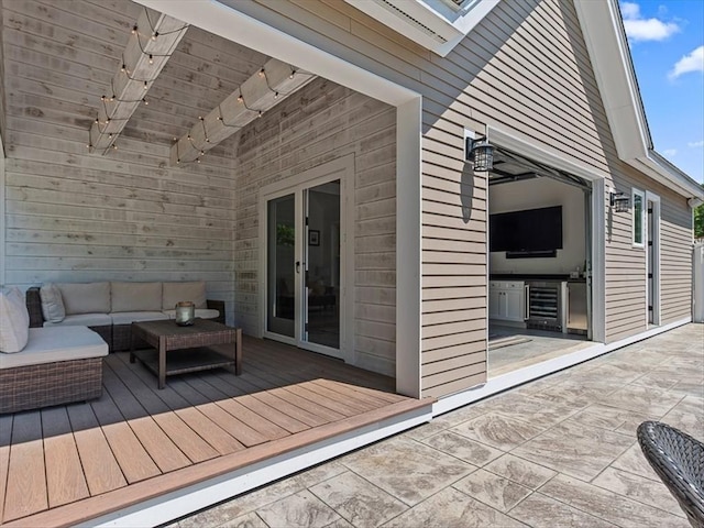 wooden terrace featuring wine cooler and an outdoor living space