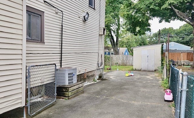 view of property exterior featuring a storage shed, a patio, and central AC