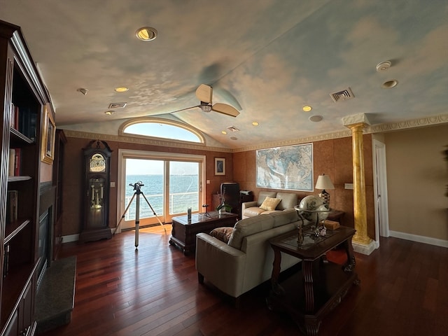 living room with lofted ceiling, dark wood-type flooring, a water view, and ornate columns