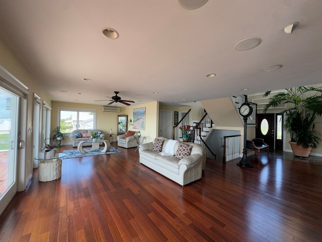 living room featuring ceiling fan, a wall unit AC, and dark hardwood / wood-style floors