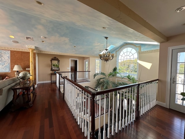 hall featuring dark wood-type flooring, plenty of natural light, and a chandelier