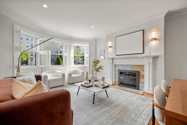 living room with light wood-type flooring, a premium fireplace, and crown molding