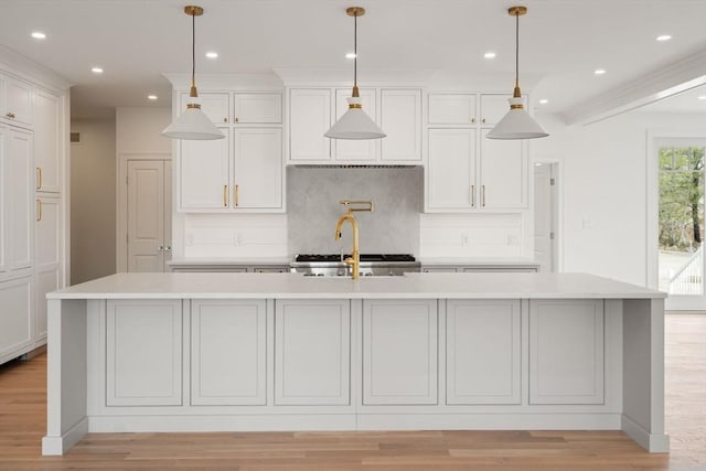 220 Atlantic St, Gloucester, MA 01930 - kitchen with light countertops, decorative backsplash, an island with sink, recessed lighting, and light wood finished floors