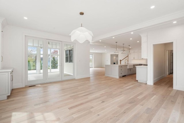 220 Atlantic St, Gloucester, MA 01930 - unfurnished living room featuring light wood finished floors, baseboards, recessed lighting, and a sink