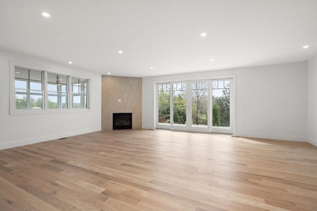 220 Atlantic St, Gloucester, MA 01930 - unfurnished living room with light wood-style floors, recessed lighting, a fireplace, and baseboards
