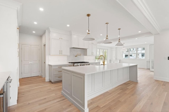 220 Atlantic St, Gloucester, MA 01930 - kitchen with a sink, a kitchen island with sink, light countertops, light wood-style flooring, and recessed lighting