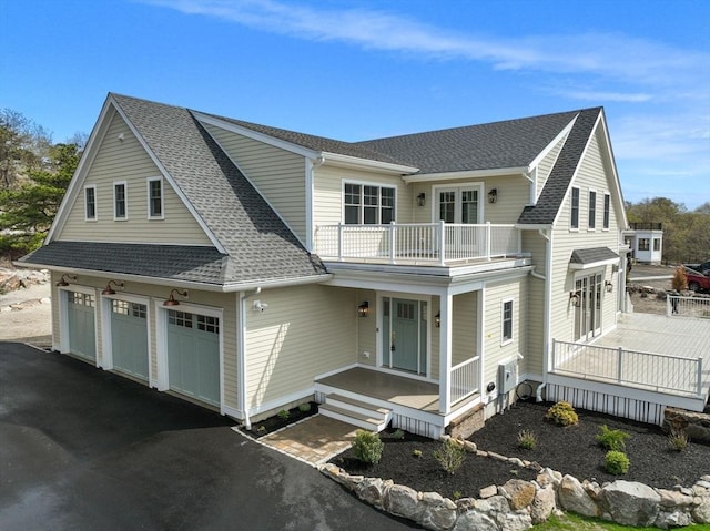 220 Atlantic St, Gloucester, MA 01930 - view of front facade with a balcony, a porch, a shingled roof, and an attached garage