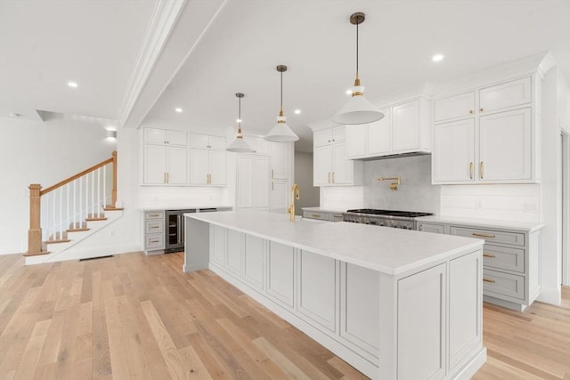 220 Atlantic St, Gloucester, MA 01930 - kitchen with backsplash, light countertops, recessed lighting, light wood finished floors, and a spacious island