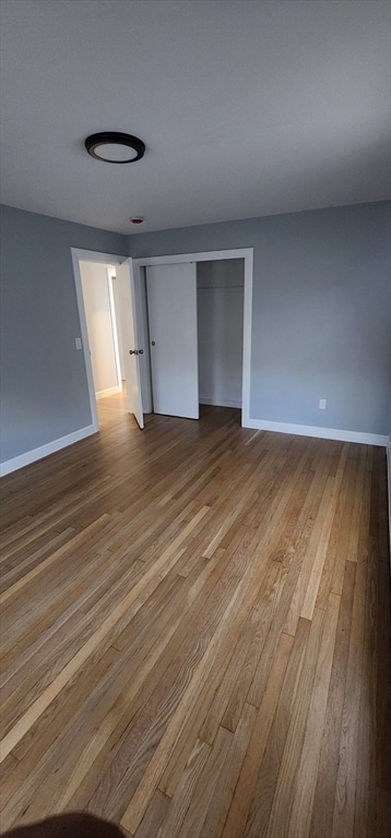 unfurnished bedroom featuring light wood-type flooring and a closet