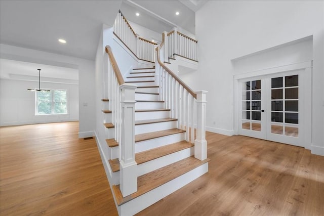 staircase featuring recessed lighting, french doors, baseboards, and wood finished floors