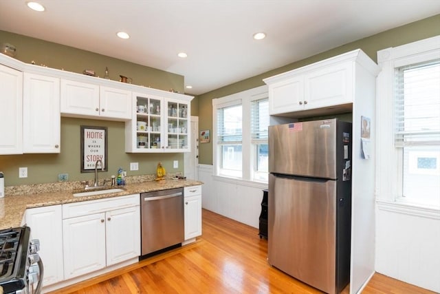 18 Dighton St Unit 18, Boston, MA 02135 - kitchen with stainless steel appliances, a sink, white cabinetry, light wood-type flooring, and a wainscoted wall