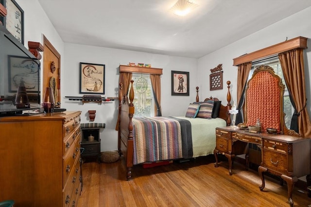 bedroom featuring multiple windows and wood finished floors
