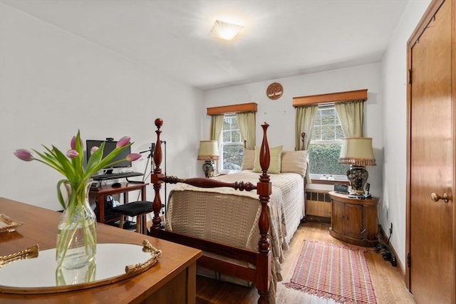 bedroom with wood finished floors and radiator heating unit
