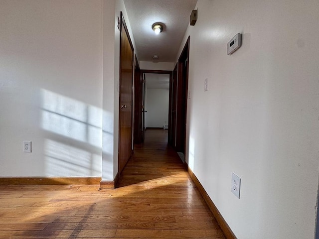 hallway with hardwood / wood-style flooring