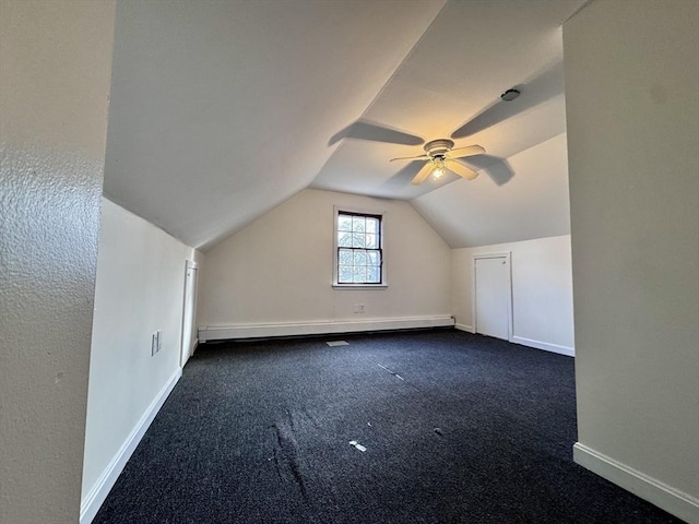 additional living space featuring lofted ceiling, dark carpet, and ceiling fan