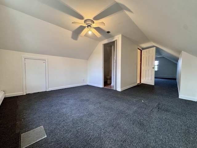 bonus room with vaulted ceiling, dark colored carpet, and ceiling fan