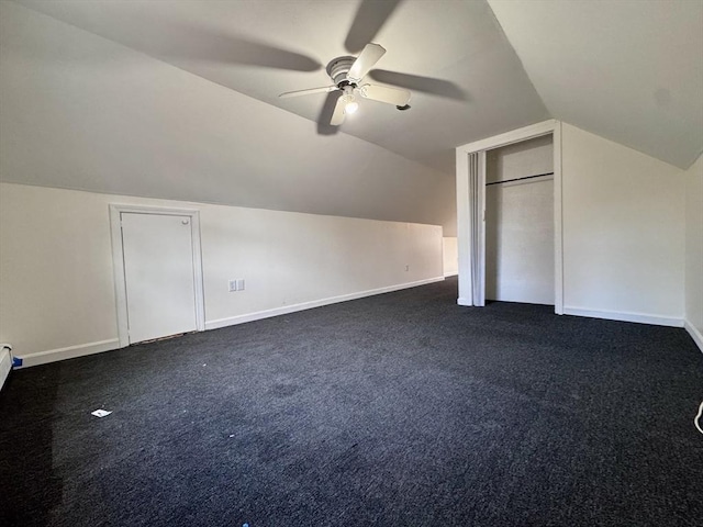 bonus room featuring ceiling fan, vaulted ceiling, and dark carpet