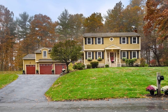 colonial home with aphalt driveway and a front lawn