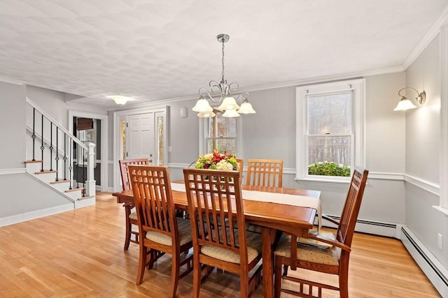 dining space with light wood-style flooring, stairs, ornamental molding, and a notable chandelier