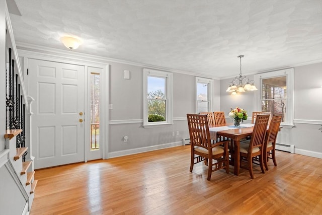 dining space with light wood finished floors, stairs, ornamental molding, and an inviting chandelier