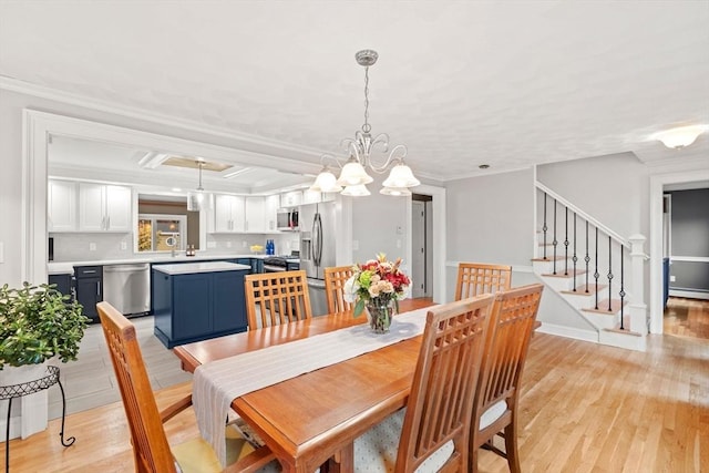 dining room featuring coffered ceiling, stairway, ornamental molding, light wood-type flooring, and a baseboard heating unit