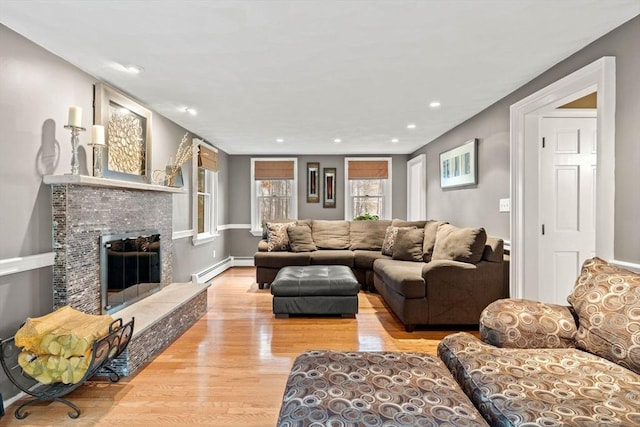 living room featuring recessed lighting, a fireplace, wood finished floors, baseboards, and baseboard heating