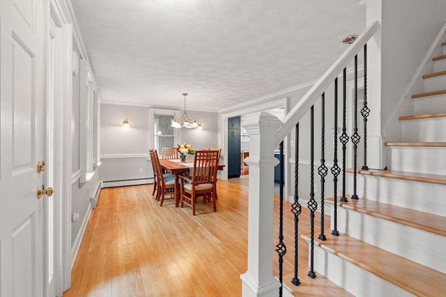 dining area featuring light wood-style flooring, stairs, ornamental molding, and a chandelier