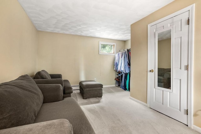 living area featuring a baseboard heating unit, carpet floors, and baseboards