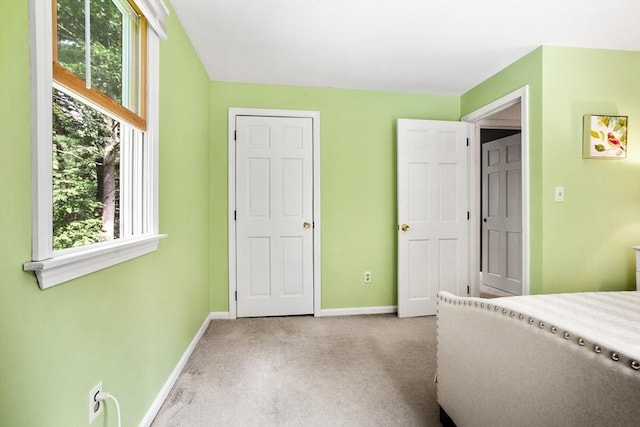 unfurnished bedroom with carpet, multiple windows, and baseboards