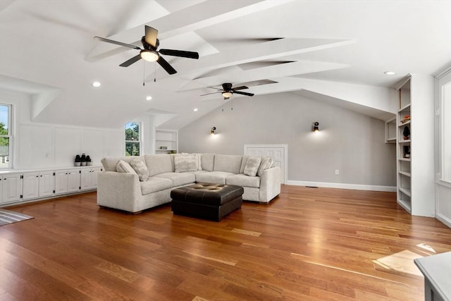 living room featuring vaulted ceiling with beams, light wood-style floors, baseboards, and recessed lighting