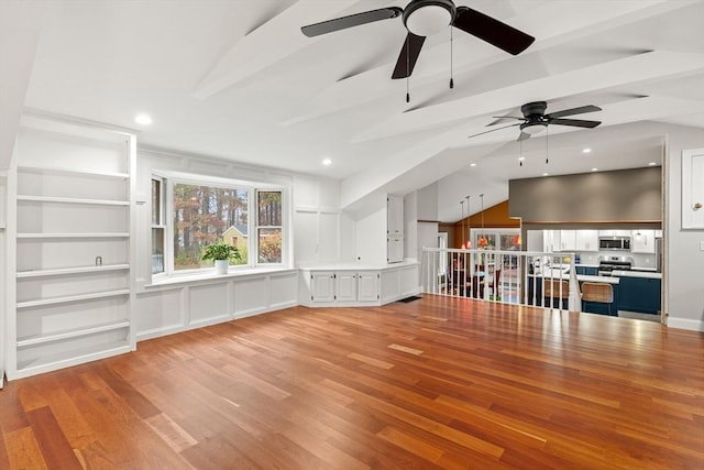 unfurnished living room featuring vaulted ceiling with beams, light wood-style floors, and recessed lighting