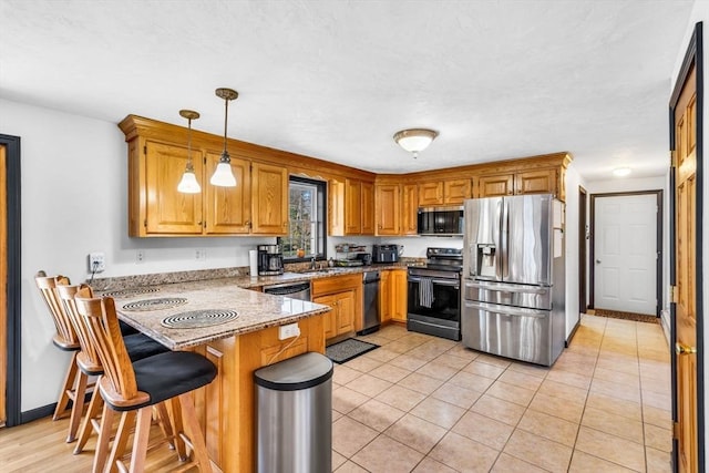 13 Old Gardner Rd, Westminster, MA 01473 - kitchen featuring hanging light fixtures, brown cabinets, a sink, a peninsula, and stainless steel appliances