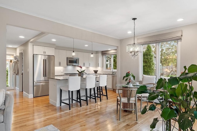 4 Greenfield Ln Unit 4, Concord, MA 01742 - kitchen with appliances with stainless steel finishes, a sink, a breakfast bar area, white cabinetry, and a kitchen island