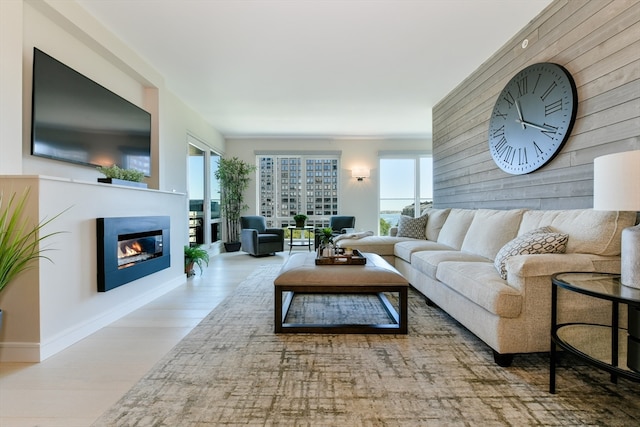 living room featuring wooden walls, plenty of natural light, and light hardwood / wood-style floors