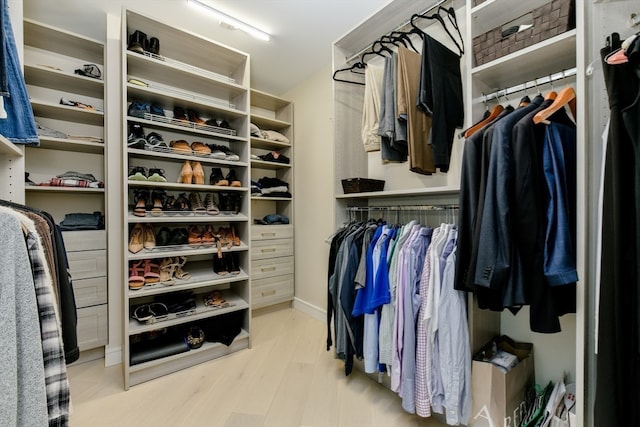 walk in closet with light hardwood / wood-style flooring